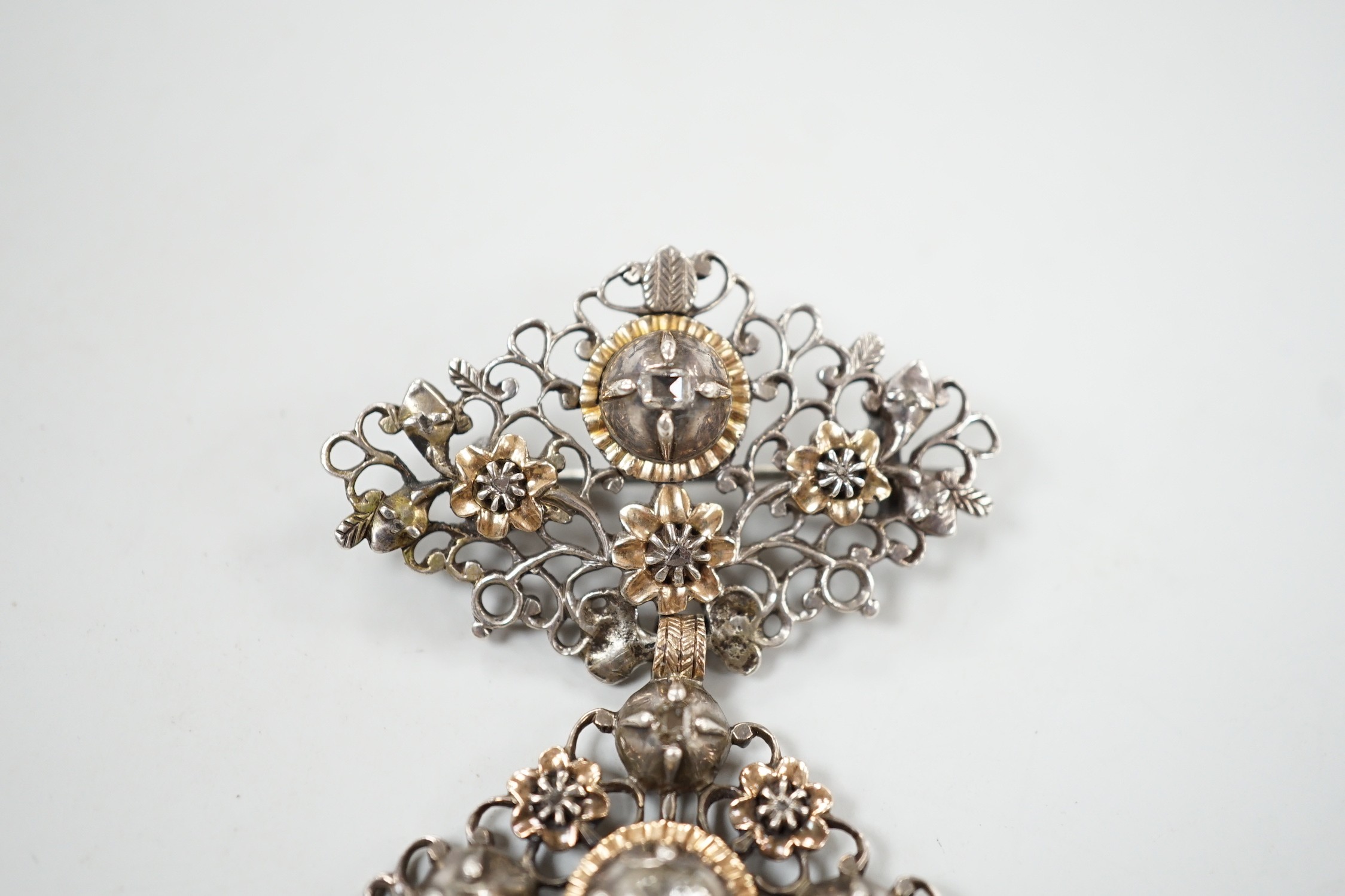 A continental antique pierced white and yellow metal, diamond set three tier drop brooch, 70mm, gross weight 13.2 grams.